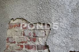 An Old Brick Wall With Gray Plaster