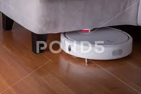 White Robot Vacuum Cleaner Runs In