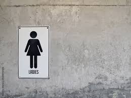 Woman Bathroom Sign On Brown Tile Wall