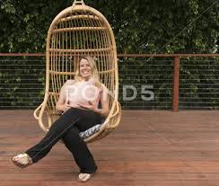Pregnant Woman Relaxing In Garden Swing