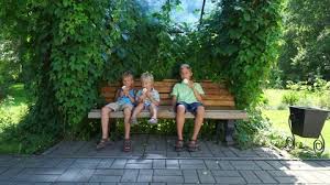 Kids Sitting On The Bench And Eating