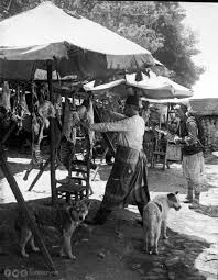 Pazarda Et Satan Bir Kasap Sirtinda Kufesi Ile Musteri Bekleyen Bir Hamal Ve Sabirla Nasibini Bekleyen Sokak Kopekleri 1898 Istanbul Nadide Fotograflar Galeri
