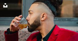 Man in red blazer drinking from clear drinking glass photo