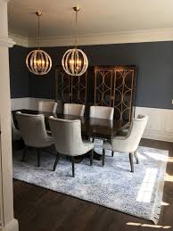 Whether considered a blessing or a curse, dark wood floors can be hard to work with. Dark Hardwood Floor With White And Light Blue Patterned Area Rug Rug Under Dining Table Dining Room Glam Black Dining Room