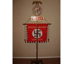 This reproduction, exacting in every detail, features the blood red silk background with white lettering and a black swastika on a white circle and trimmed with alternating red, black & white fringe. Deutschland Erwache Standarte Reproduction