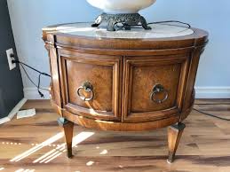 You can use end tables with storage to keep your gadgets, books, and magazines. Vintage Round Side Table With Marble Top And 2 Door Cabinet For Storage Below