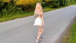 Bionda birichina che gioca con la sua figa su un prato per strada