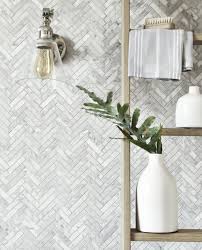 This master bathroom by mia rao design with double vanity features shiny white marble on the floor and walls, with an interesting contrasting wall in black. 25 Bathrooms On A Budget Affordable Ways To Transform Your Space Marble Herringbone Tile Herringbone Tile Floors Herringbone Tile