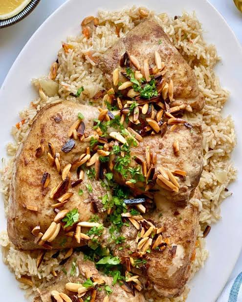 All ingredients for Instant Pot Kabsa laid out on a wooden board including basmati rice chicken spices cardamom cinnamon and tomatoes