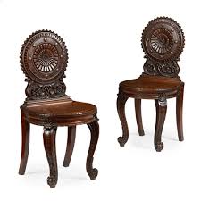 Pair Of Early Victorian Mahogany Hall Chairs By Wylie Lockhead Glasgow Mid 19th Century The Circular Shield Backs Carved With Stylized Sunflowers Roundels A
