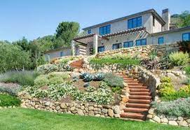 The house appears to resemble buildings found commonly in dragonkin architecture. House On A Hill Landscaping House On The Hill Mediterranean Landscape Backyard Hill Landscaping Sloped Backyard Landscaping On A Hill