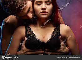 Handsome man is holding womans breast in hands and kissing her in the neck  Stock Photo by ©1greyday 265746778