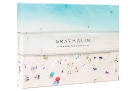 The hawaii beach double sided 500 piece puzzle features sunseekers basking on a sandy beach on one side and snorkelers exploring a stunning ocean reef on the other side. The Hawaii Two Sided Puzzle Gray Malin