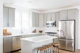 The gold touch adds up the luxuriousness to space! Light Grey Shaker Kitchen Cabinets With White Quartz Countertops Transitional Kitche Kitchen Cabinets Decor Grey Shaker Kitchen Light Grey Kitchen Cabinets