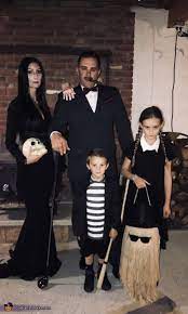 Hair is straight parted down the middle with red lipstick and red nails. Addams Family Halloween Costume Contest At Costume Works Com Addams Family Halloween Costumes Family Halloween Costumes Diy Scary Halloween Costumes