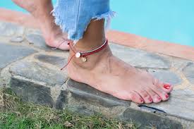 woman feet with ankle cuff wearing jeans by the pool Stock Photo | Adobe  Stock