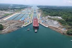 Aerial view of a large cargo ship navigating through the locks of the Panama Canal.