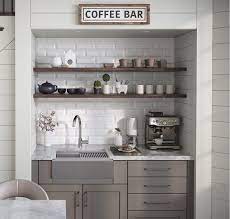 The coffee station sits on top of a small counter with a variety of mugs available on the shelving above. Creating A Cozy And Practical Coffee Nook