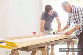 Contact father and son construction customer service. Father And Son Looking Through Construction Plans Blueprints Teaching Stock Photo 199366054