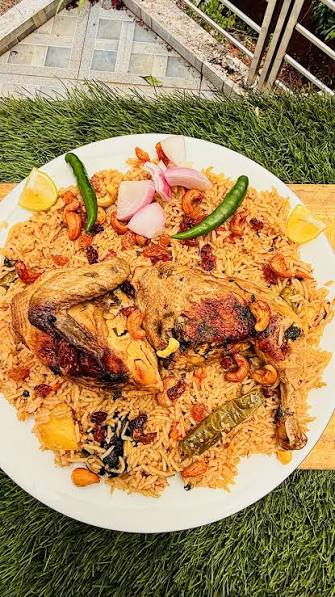 Pressure cooker preparing Madghout rice with lamb and aromatic Gulf spices steaming on a stovetop