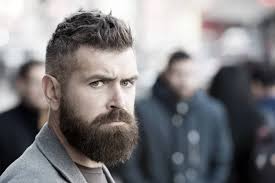 Med stil. Brutal, kaukasisk hipster med bart. En skjeggete mann. Moden  hipster med skjegg. Fremtidig suksess. Mannlig mote. Forretningsmann mot  himmelen. Får hår til å se magisk ut. kopieringsareal