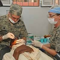 Cmdr. Sandra Halterman and Hospital Corpsman 2nd Class Adam J. Smolski  prepare a patient for dental surgery aboard USS George H.W. Bush (CVN 77). 