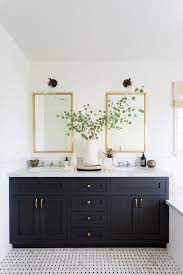 The stark black color is gorgeous against the white marble floors and white wall paint. 8 Black Bathroom Cabinet Ideas That You Ll Want To Copy Now Hunker Black Cabinets Bathroom Modern Bathroom Design Trendy Bathroom