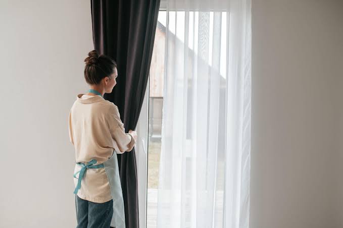 DA8 specialist hanging drapes on curtain rail in modern apartment
