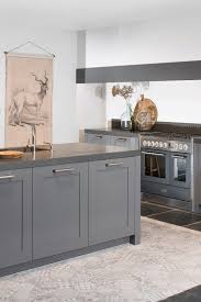 grijze landelijke keuken met eiland voorzien van fornuis en ingebouwde kastenwand bekijk meer foto s op onze website keuken inspiratie keuken keuken idee