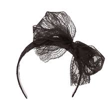 By tying it with this playful hair band featuring a bow! 80s Black Headband Party City