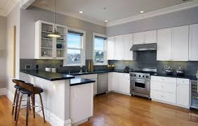Gray countertops blend seamlessly with a contemporary light fixture, deep blue cabinets, and a zinc range hood, creating a stunning kitchen that's gray countertops become even classier when when they're made with soapstone. White Kitchen Cabinets With Granite Countertops Designing Idea