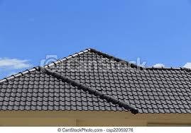 Fence made of sharp wooden stakes. Black Tiles Roof On A New House With Blue Sky Canstock