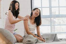 Asian Lesbian lgbtq women couple massage each other at home. Young Asia  lover female happy relax rest together after wake up, body wellness in  bedroom at home in the morning concept. 5494481