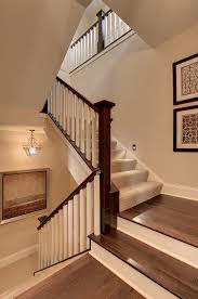Will the staircase carpet trend last in 2021 and beyond? How To Install Carpet On Stairs For Traditional Staircase Also Beige Painted Wall Carpet Runner Carpeting Dark Brown Handrail Earth Tones Framed Art Landing Neutral Colors Pendant Steps White Banister White Baseboard