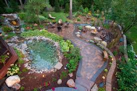 Invite your neighbor over to idle away an afternoon with interesting conversation and a nice cup of tea. Paver Patio With Natural Rock Pond And Cozy Seating Areas Mickman Brothers Hgtv
