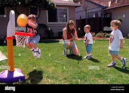 JANE REILLY 1/C/24MAR97/PZ/LH-As her three year old son, John, goes for the  hoop[, Jane Reilly fixes her 19 month old, Jimmy's sword as her nephew John  Biebel (right), 3 years old, watches.