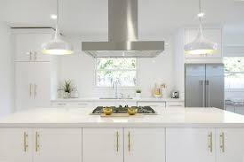 The front is adorned with a gold lattice design for a lavish, luxurious look. White And Gold Kitchen With Long Brushed Brass Pulls Contemporary Kitchen