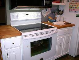 The kitchen offers a rough wood counter surrounding a double basin farmhouse sink with painted white cabinetry. Why White Kitchens Stand The Test Of Time Kitchen Tips