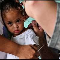 Cmdr. Kerry Ebueng examines a patient at a medical site established at  Centro de Educacion Basica Dr. Jesus Aquilar Paz