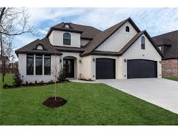 Black And White House With Wood Garage Door Painted White Brick House With Board And Batten Over Garage Black Trim Black Soffit Black House Paint Exterior Painted White Brick House White Brick Houses