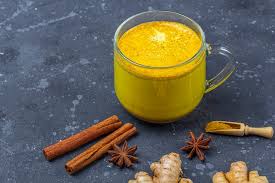 Bebida tradicional india leche dorada en taza de vidrio con cúrcuma y jengibre 