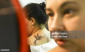 Gina Jacobson waits to get a tattoo from Fallen Heroes