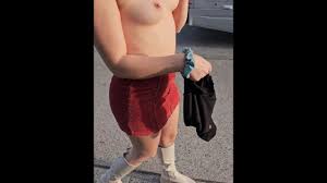 Chica exhibicionista muestra las tetas y el coño en la calle ocupada