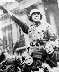 IDEA - ALM : Leon Degrelle, Belgian Fascist leader, saluting a parade of the Belgian SS Division.