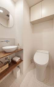 ミサワホームイングデザインリフォーム トイレ 手洗いコーナーのリフォーム トイレを少し広げて手洗いスペースを設けタンクレストイレにしました 手洗いカウンターは耐水塗装仕上げ 丸い鏡とベッセル式 置き型 の手洗器でやわらかな印象にまとめました 床は淡い