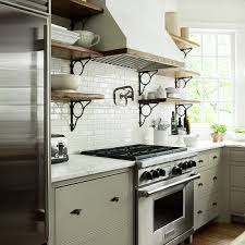 This rustic kitchen features golden brown shaker cabinetry paired with a mint green wall hue and neutral tile backsplash. Iron And Wood Rustic Kitchen Shelves Design Ideas