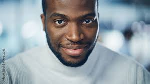 Close-up Portrait of Handsome Black Man with Deep Brown Eyes, Trimmed  Beard, Wearing Stylish Turtleneck, Smiles Charmingly. Attractive Authentic  African American Gentleman Looks up at the Camera Stock Photo