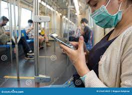 Young Asian Japanese Woman Wearing Face Mask and Using Smart Phone in BTS Subway  Train Bangkok City, Thailand. Social Distancing Stock Photo 