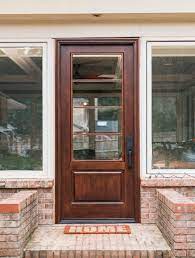 Solid wood front entry door with glass window (upper part of the door). Farmhouse Door Masterpiece Doors Custom Composite Entry Doors
