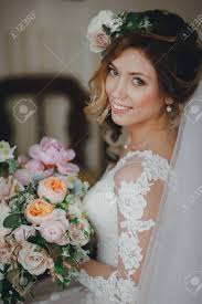 Maybe you would like to learn more about one of these? A Beautiful Bride With A Wedding Bouquet And Flowers In Her Hair Looks At The Camera Morning Preparations Of The Bride Stock Photo Picture And Royalty Free Image Image 133080368